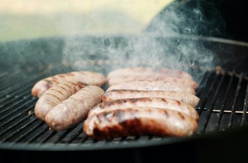 Italian sausages cooking on a grill
