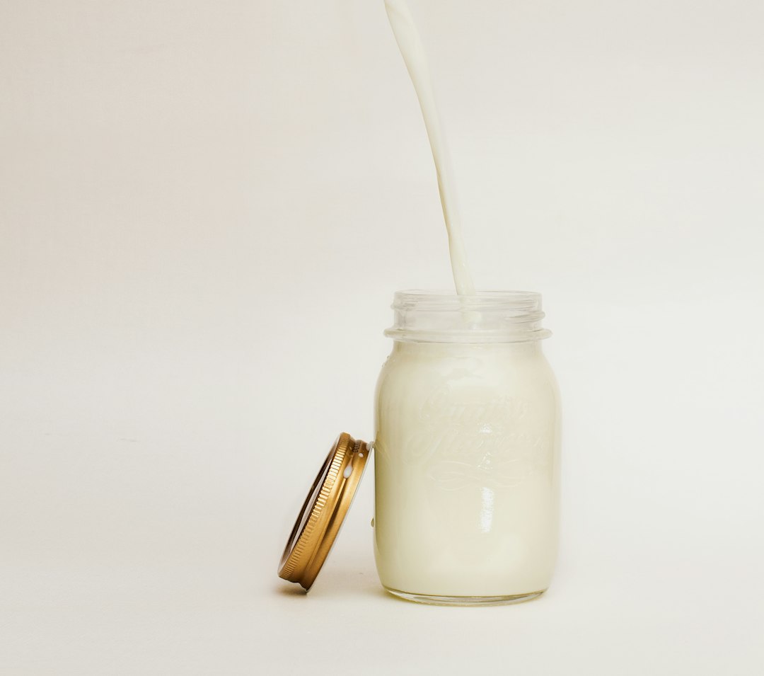 Milk poured into a glass jar for a heavy cream substitute for cooking