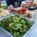 Cooked broccoli florets in a foil tray on an outdoor table