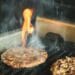 Beef burger patties cooking on an outdoor grill