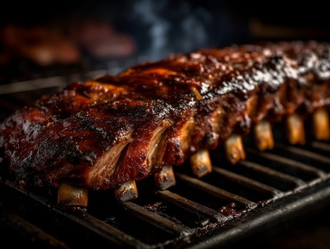 Ribs cooking on a grill with barbecue glaze