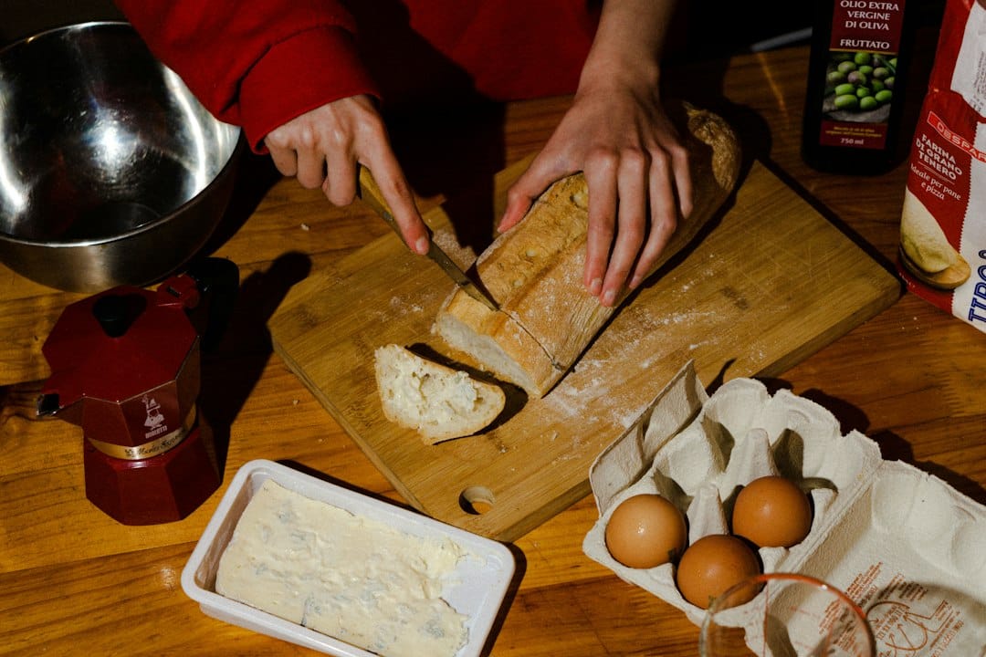 A person slicing bread on a cutting board
