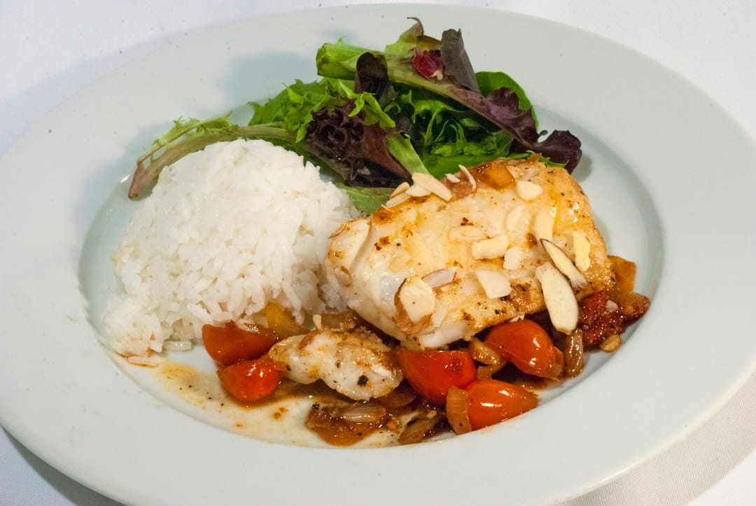 Cooked cod served over stewed tomatoes