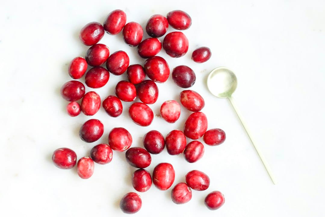 Fresh cranberries on a white surface