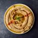 Bowl of hummus with chickpeas and herbs, an ingredient reference for turkey hummus pinwheels