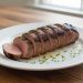 Sliced grilled pork tenderloin on a white platter
