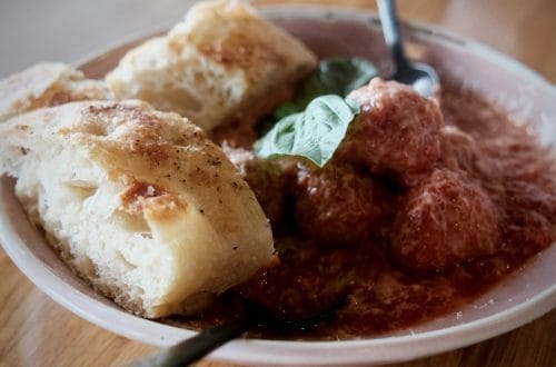 Meatballs in tomato sauce served with focaccia bread and basil