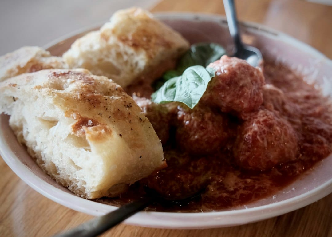 Meatballs in tomato sauce served with focaccia bread and basil