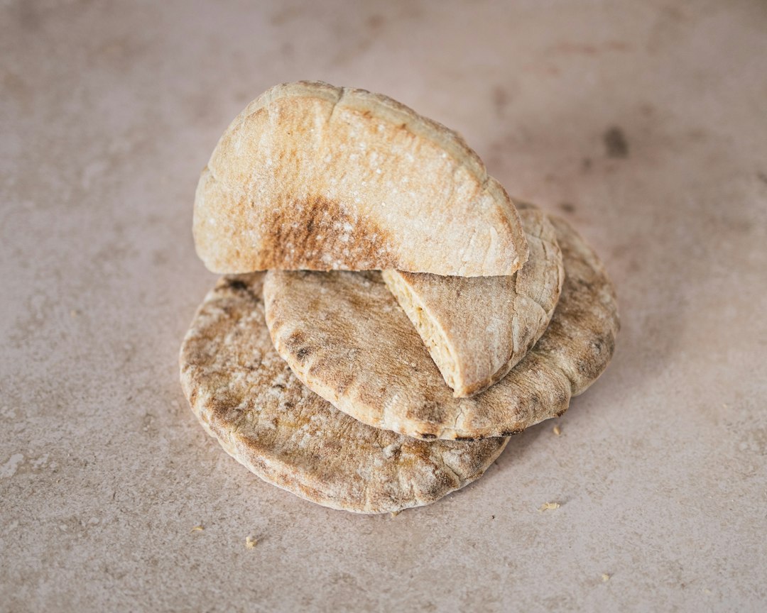 Two pita breads on a stone surface