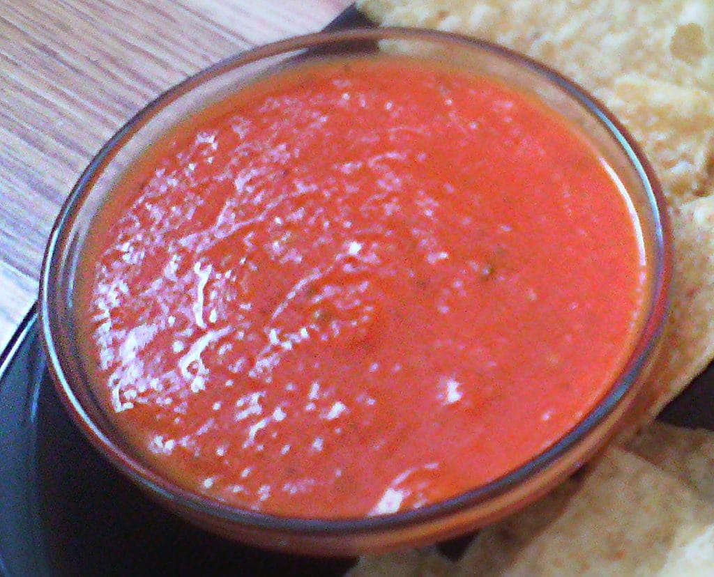 Smooth red tomato salsa in a glass bowl