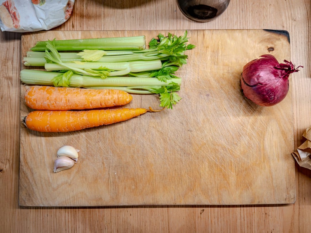 Celery, carrots, red onion and garlic on a cutting board