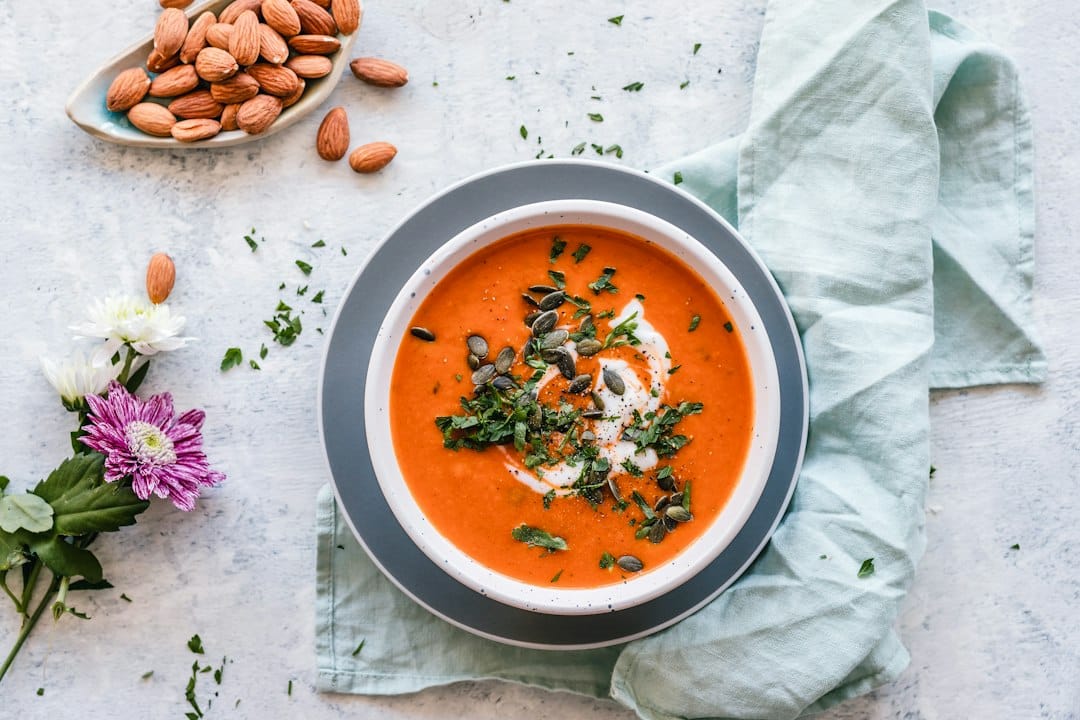 Smooth orange soup in a bowl with a garnish