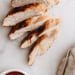 Sliced browned chicken breast on a white plate