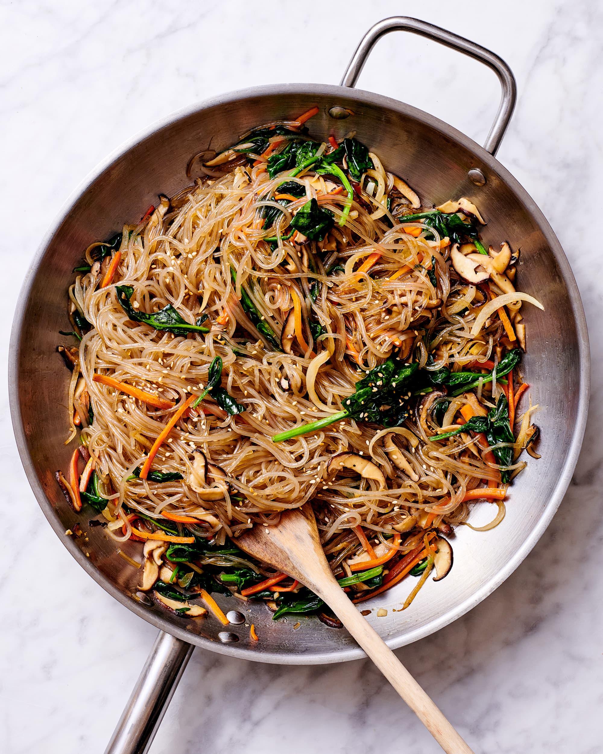 Glass noodles and sliced vegetables presented in a skillet