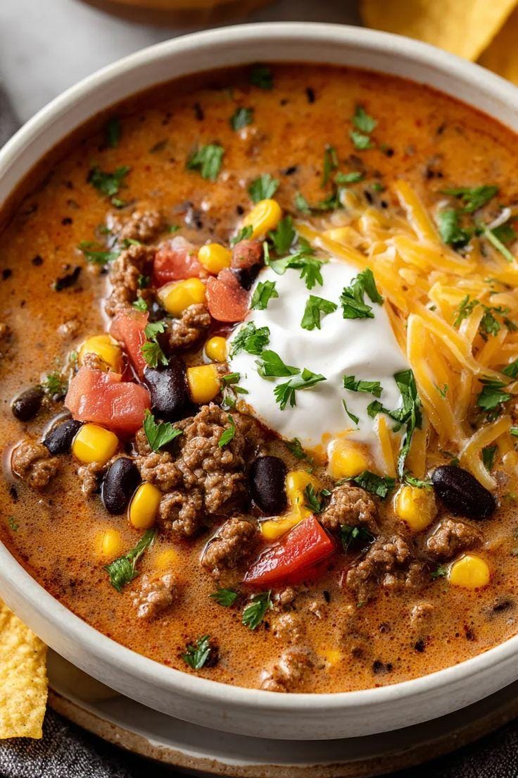 Taco soup recipe with ranch seasoning served with beans, corn, sour cream, cheese and cilantro