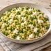 Warm pearl couscous with frozen peas and feta finished with lemon and dill