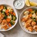 Air fryer salmon bites with frozen vegetables for two in serving bowls with cooked broccoli, cauliflower and carrots.