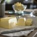 Butter pieces on their wrapper beside a knife for a guide to softening butter without melting