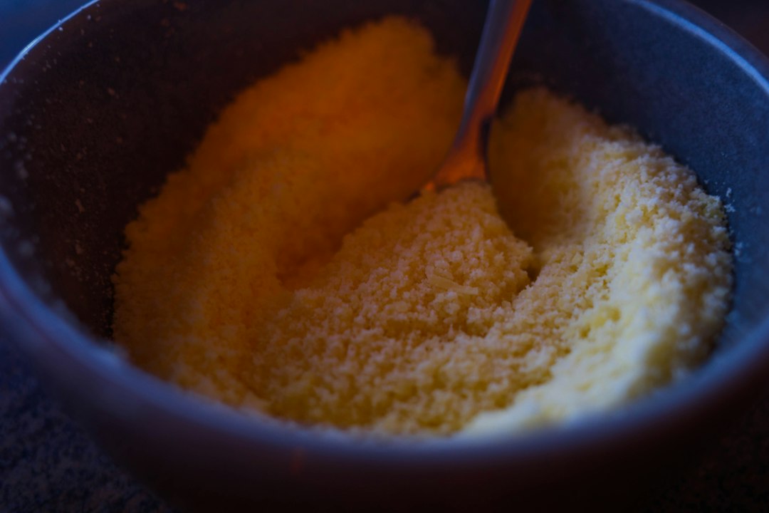 Dry yellow cornmeal in a bowl with a spoon, an ingredient reference for chickpea polenta bowls without tomatoes