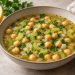Chickpea and celery lemon soup with whole chickpeas, celery slices and parsley in a light golden broth.