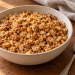 Cider vinegar peanut butter granola with toasted oat clusters and chopped peanuts in a bowl