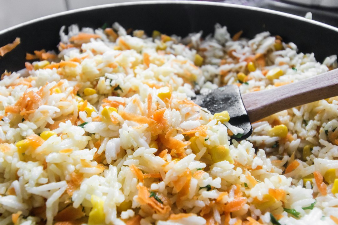 Fried rice with vegetables in a black pan