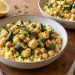 Two bowls of fluffy millet with chickpeas, golden zucchini cubes, and chopped parsley.