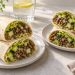 Two large lentil cucumber wraps cut diagonally, showing whole lentils, small cucumber dice, red onion and shredded lettuce.