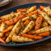 Roasted carrots and parsnips with a light mustard-seed glaze on a dark-blue platter