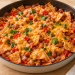 Pinto bean enchilada skillet with small tortilla pieces, red pepper and melted cheddar