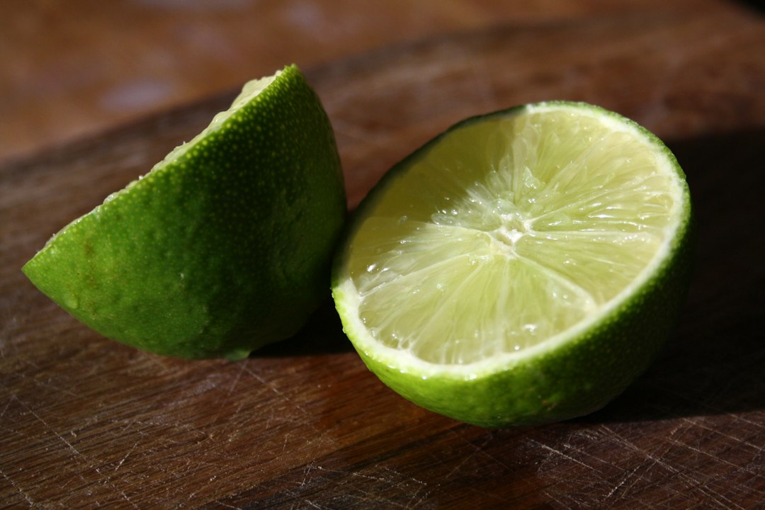 A fresh lime cut in half on a cutting board
