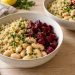 Two bowls of white quinoa, large butter beans, and diced cooked beets with parsley and lemon dressing.