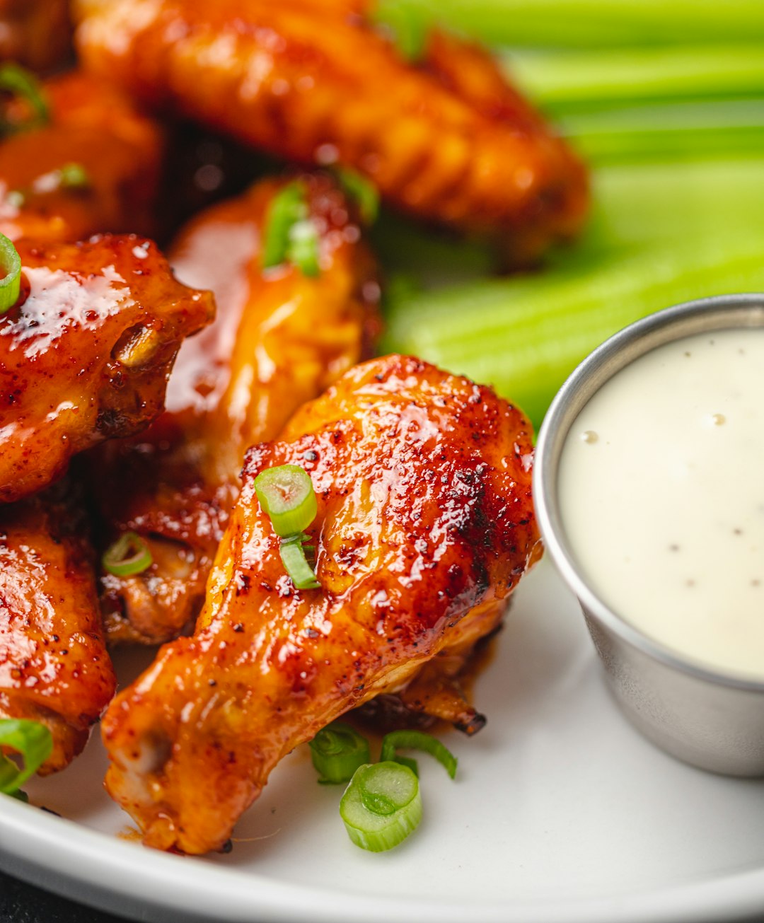 Sauced chicken wings served with celery and a creamy dip