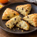 Four small orange raisin scones with one gently split open
