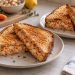 Golden toasted sandwiches cut to show a soft cannellini bean filling with grated carrot and tiny herb flecks.