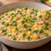 Savory oatmeal with green peas and melted cheddar in a ceramic bowl